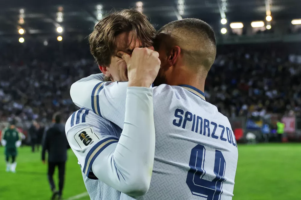 Italy's Marco Palestra, left, and Leonardo Spinazzola console each other after losing a penalty shootout during the World Cup qualifying playoff final soccer match between Bosnia and Italy in Zenica, Bosnia, Tuesday, March 31, 2026. (AP Photo/Armin Durgut)