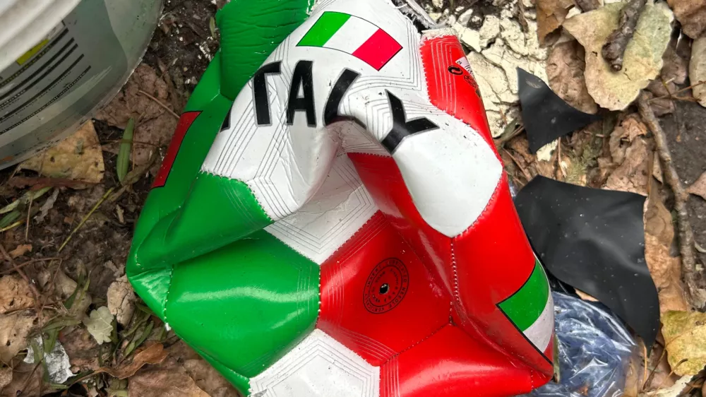 A broken soccer ball is pictured on a street in Rome, Wednesday, April 1, 2026. (AP Photo/Gregorio Borgia)