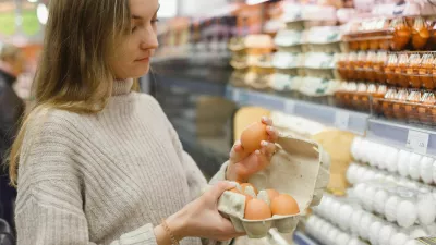 Woman chooses chicken eggs in a farm food store. Food consumption, Easter. / Foto: Vladdeep