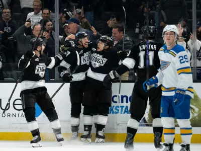 Los Angeles Kings left wing Trevor Moore, center, celebrates his game-winning goal with his teammates during overtime in an NHL hockey game against the St. Louis Blues, Wednesday, April 1, 2026, in Los Angeles. (AP Photo/Kyusung Gong)