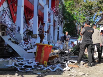 Police officers inspect a damaged building following an earthquake in Manado, North Sulawesi, Indonesia, Thursday, April 2, 2026. (AP Photo/Tonny Rarung)