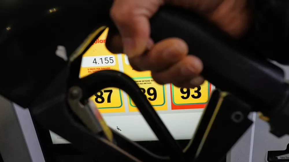 A person fills up her vehicle's gas tank at a gas station in Buffalo Grove, Ill., Thursday, April 2, 2026. (AP Photo/Nam Y. Huh)