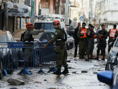 Emergency personnel work next to a damaged building at an impact site, following a barrage of missiles launched from Iran, amid the U.S.-Israeli conflict with Iran, in Tel Aviv, Israel April 6, 2026. REUTERS/Florion Goga