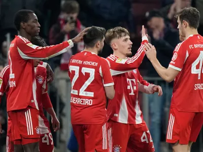 Bayern's Nicolas Jackson, left, celebrates with team mates Raphael Guerreiro (22), Lennart Karl (42) and Josip Stanisic (44) after scoring his side's fourth goal during the Bundesliga soccer match between FC Bayern Munich and Borussia Moenchengladbach in Munich, Germany, March 6, 2026. (AP Photo/Matthias Schrader)