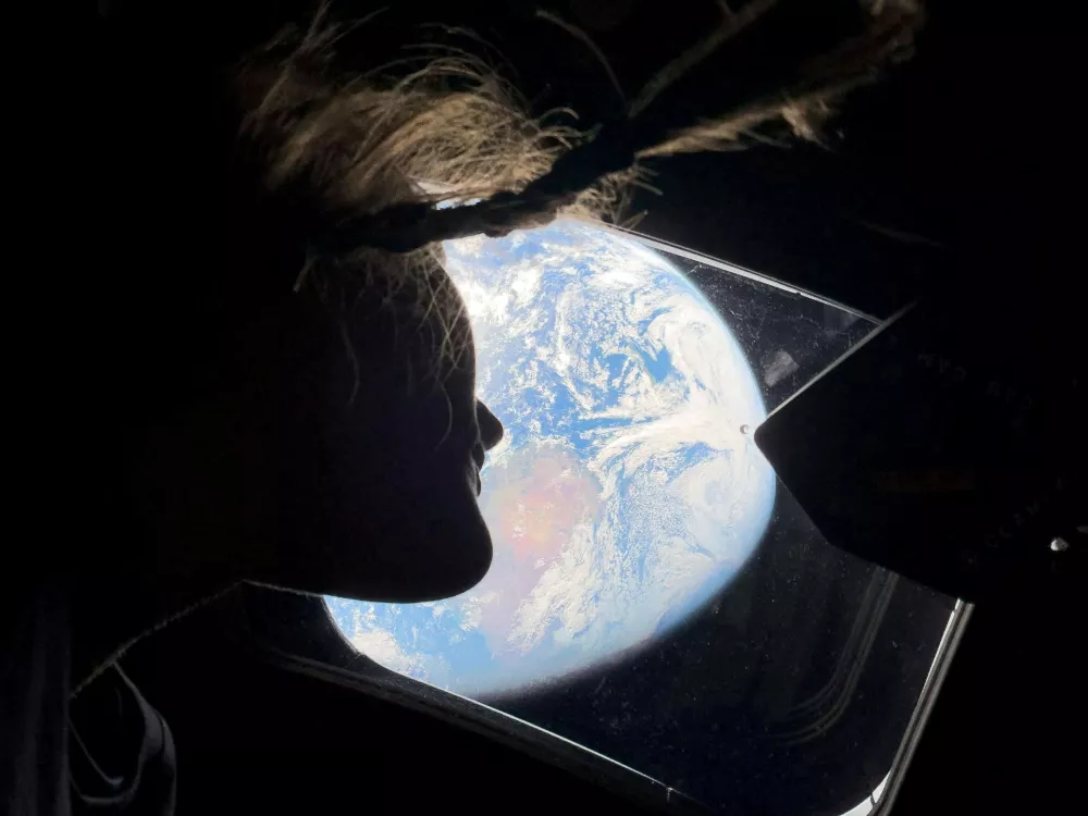 NASA astronaut and Artemis II mission specialist Christina Koch peers out of one of the Orion spacecraft's main cabin windows, looking back at Earth, as the crew travels towards the Moon April 2, 2026. NASA/Handout via REUTERS. THIS IMAGE HAS BEEN SUPPLIED BY A THIRD PARTY. REFILE - CORRECTING YEAR FROM "2024" TO "2026".