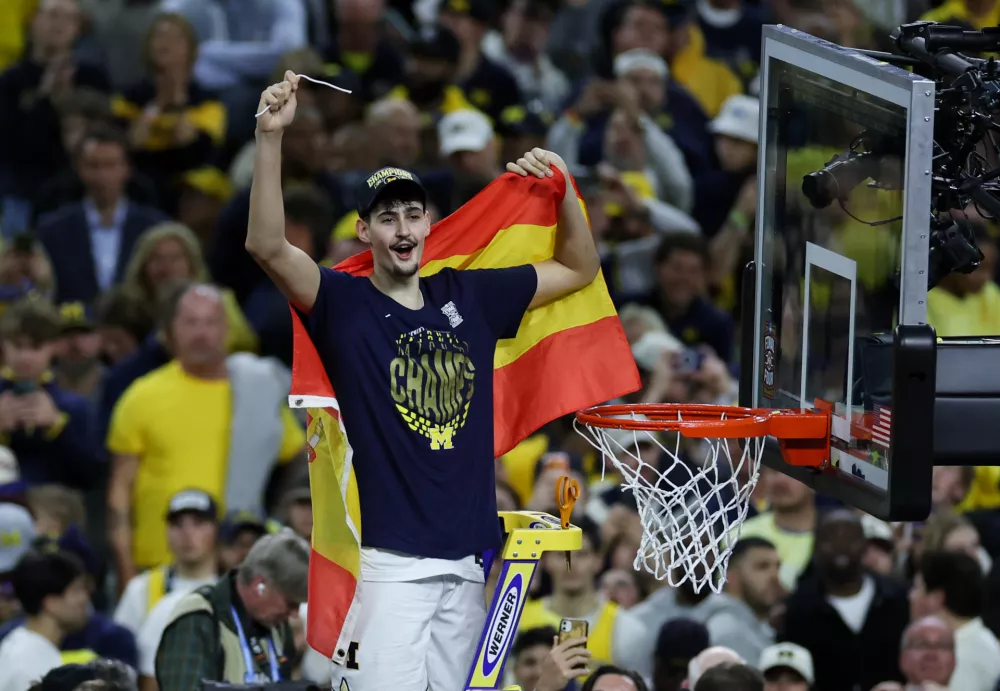 Apr 6, 2026; Indianapolis, IN, USA; Michigan Wolverines center Aday Mara (15) cuts down the net after defeating the UConn Huskies in the national championship of the Final Four of the men's 2026 NCAA Tournament at Lucas Oil Stadium. Mandatory Credit: Trevor Ruszkowski-Imagn Images