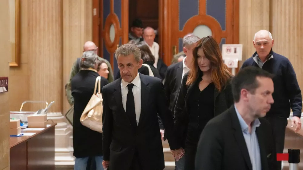 Former French President Nicolas Sarkozy and his wife Carla Bruni-Sarkozy leave the appeals courthouse in Paris, France, Tuesday, April 7, 2026, during his trial appealing a conviction involving illegal campaign funds from Libya. (AP Photo/Thibault Camus)