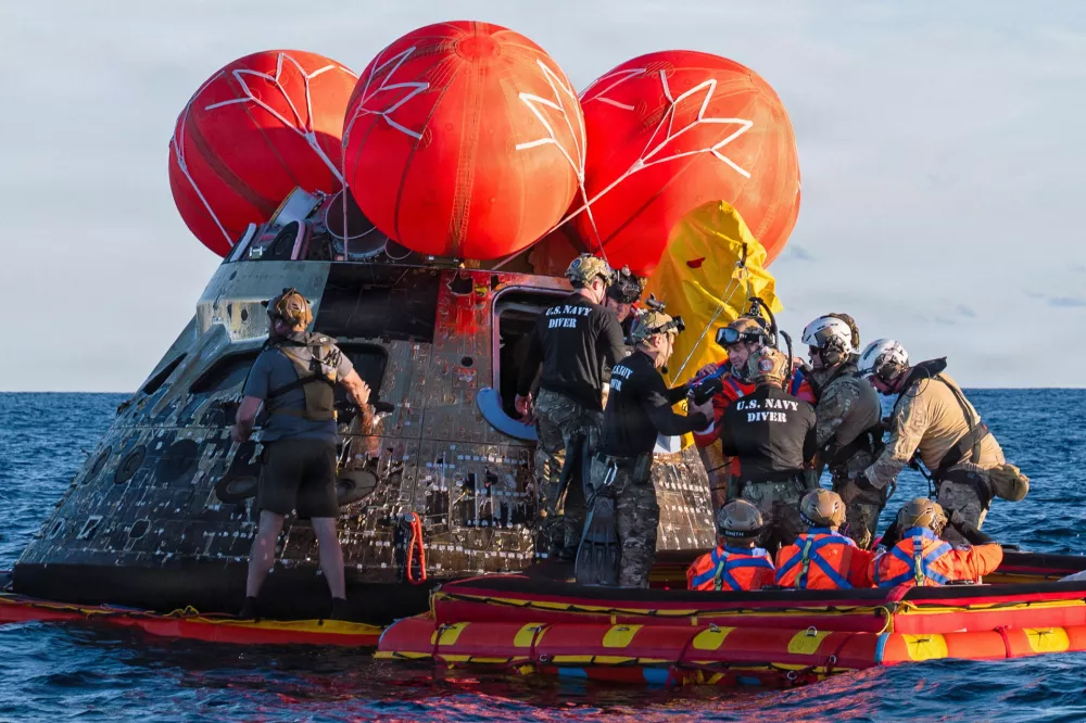 NASA Astronaut Reid Wiseman, Artemis II mission commander, exits the Orion crew module to join the three other crew in a raft, before transiting to the U.S. Navy ship USS John P. Murtha in the Pacific Ocean off the coast of California, U.S. April 10, 2026. NASA's Artemis II mission sent four astronauts on a flight around the moon in the Orion space capsule, which splashed down after the ten day journey. U.S. Navy/Mass Communication Specialist David Rowe/Handout via REUTERS THIS IMAGE HAS BEEN SUPPLIED BY A THIRD PARTY. THIS IMAGE WAS PROCESSED BY REUTERS TO ENHANCE QUALITY, AN UNPROCESSED VERSION HAS BEEN PROVIDED SEPARATELY. / Foto: Us Navy