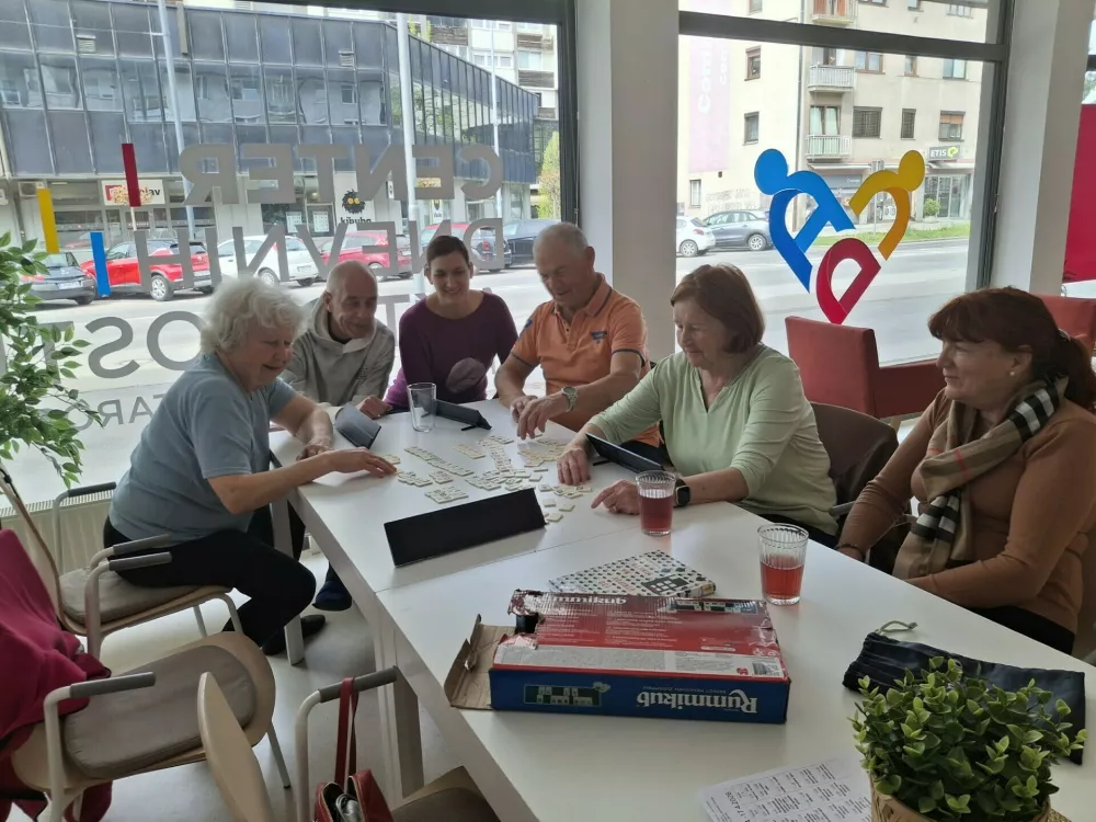 Igranje družabnih iger je izjemno priljubljeno in eden od igralcev nam pove, da sedaj, ko so v pokoju, komaj čakajo nedeljo, saj je po njej spet ponedeljek, ko je čas za prijetno druženje v centru. / Foto: Meta Černoga