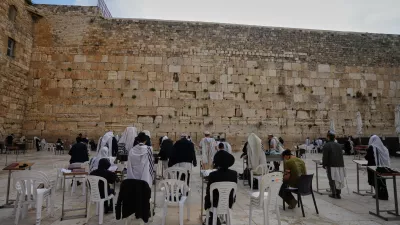 Ultra-Orthodox Jewish men pray at the Western Wall, the holiest site where Jews can pray, after restrictions were lifted following a ceasefire reached between Iran, Israel and the United States, in the Old City of Jerusalem, Thursday, April 9, 2026. (AP Photo/Mahmoud Illean)