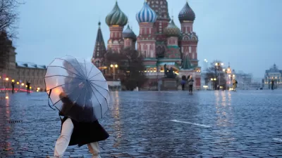 A woman holds an umbrella while she walks through Red Square as it drizzles in Moscow, Thursday, April 9, 2026. (AP Photo/Pavel Bednyakov)