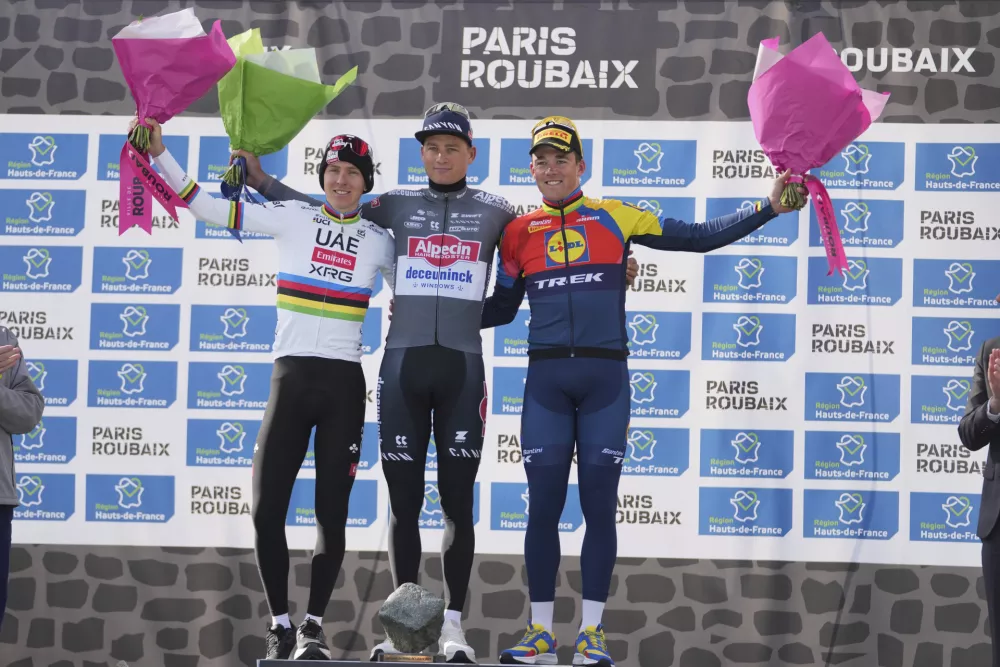 Second placed, Tadej Pogacar, of Slovenia, winner Mathieu van der Poel, of the Netherlands, and third placed Mads Pedersen, of Denmark, pose on the podium of the Paris-Roubaix cycling race in Roubaix, France, Sunday, April 13, 2025. (AP Photo/Thibault Camus)