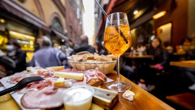 Meat plate with sliced italian sausages, proscutto, cheese, bread and Spritz Aperol drink on a table at outdoor bar on crowded street background / Foto: Rosshelen Getty Images/istockphoto