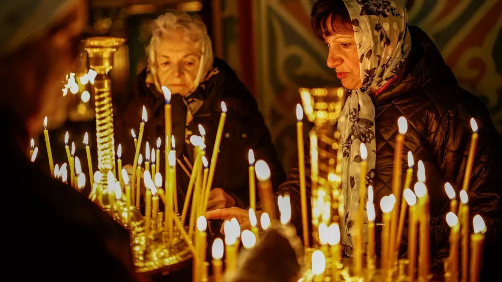 FILE PHOTO: Believers light candles during a service ahead of Orthodox Easter, during a 32‑hour ceasefire declared by Russia, inside the St. Michael's Cathedral, amid Russia's attack on Ukraine, in Kyiv, Ukraine April 11, 2026. REUTERS/Alina Smutko/File Photo