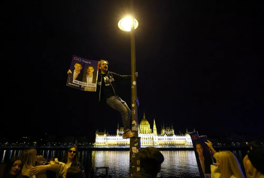 Supporters of Peter Magyar, leader of the opposition Tisza party, celebrate across the River Danube from the Parliament building, after Hungarian Prime Minister Viktor Orban conceded defeat in the parliamentary election, in Budapest, Hungary, April 13, 2026. REUTERS/Lisi Niesner