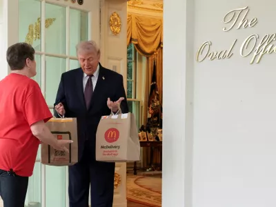 U.S. President Donald Trump receives a McDonald's delivery via DoorDash from Sharon Simmons outside the Oval Office at the White House, in Washington, D.C., U.S., April 13, 2026. REUTERS/Jonathan Ernst    TPX IMAGES OF THE DAY
