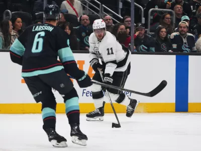 Los Angeles Kings center Anze Kopitar moves the puck against Seattle Kraken defenseman Adam Larsson (6) during the second period of an NHL hockey game Monday, April 13, 2026, in Seattle. (AP Photo/Lindsey Wasson)