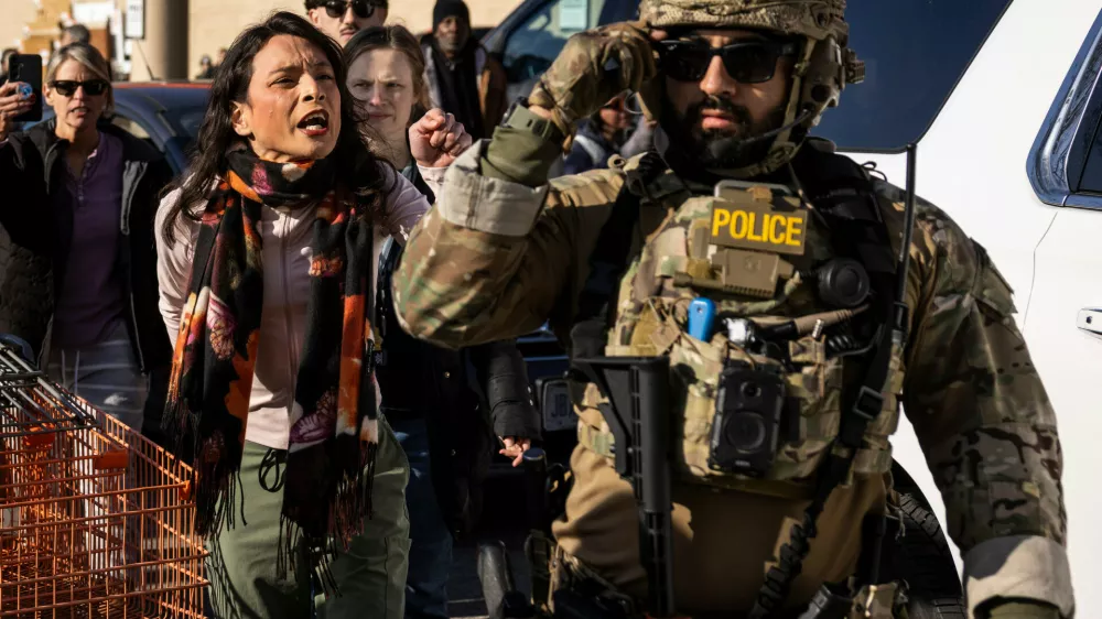 Community members and rapid responders yell at federal immigration enforcement agents after they detained two men outside a Home Depot in Evanston in Evanston, Ill., Wednesday, Dec. 17, 2025. (Ashlee Rezin/Chicago Sun-Times via AP)