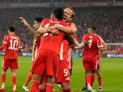 Bayern's Michael Olise celebrates with Harry Kane after scoring his side's fourth goal uring the Champions League quarterfinal second leg soccer match between Bayern Munich and Real Madrid in Munich, Germany, Wednesday, April 15, 2026. (AP Photo/Matthias Schrader)