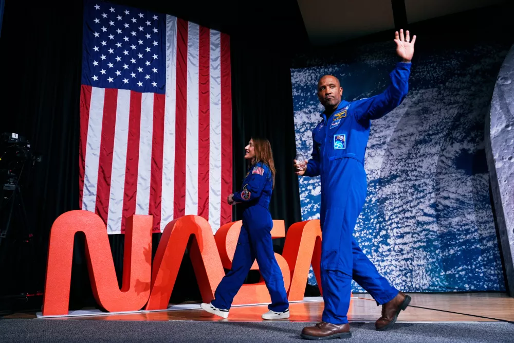 NASA astronauts Victor Glover and Christina Koch, both members of the NASA's Artemis II crew, leave a press conference on Thursday, April 16, 2026, in Houston. (AP Photo/Ashley Landis)