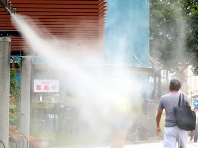 August 6, 2025, Tokyo, Japan - A pedestrian gets water mist shower to cool down at Tokyo's Ginza fashion district on Wednesday, August 6, 2025. Tokyo's temperature climbed to 37 degree Celsius on August 6 while Tokyo's suburban Isesaki city in Gunma prefecture marked Japan's record-high of 41.8 degree Celsius on August 5.,Image: 1028198254, License: Rights-managed, Restrictions: No third party sales, Model Release: no