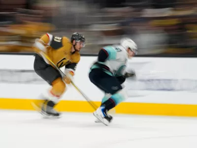 Vegas Golden Knights center Brett Howden, left, and Seattle Kraken defenseman Ryker Evans (41) battle for the puck during the second period of an NHL hockey game Wednesday, April 15, 2026, in Las Vegas. (AP Photo/John Locher)
