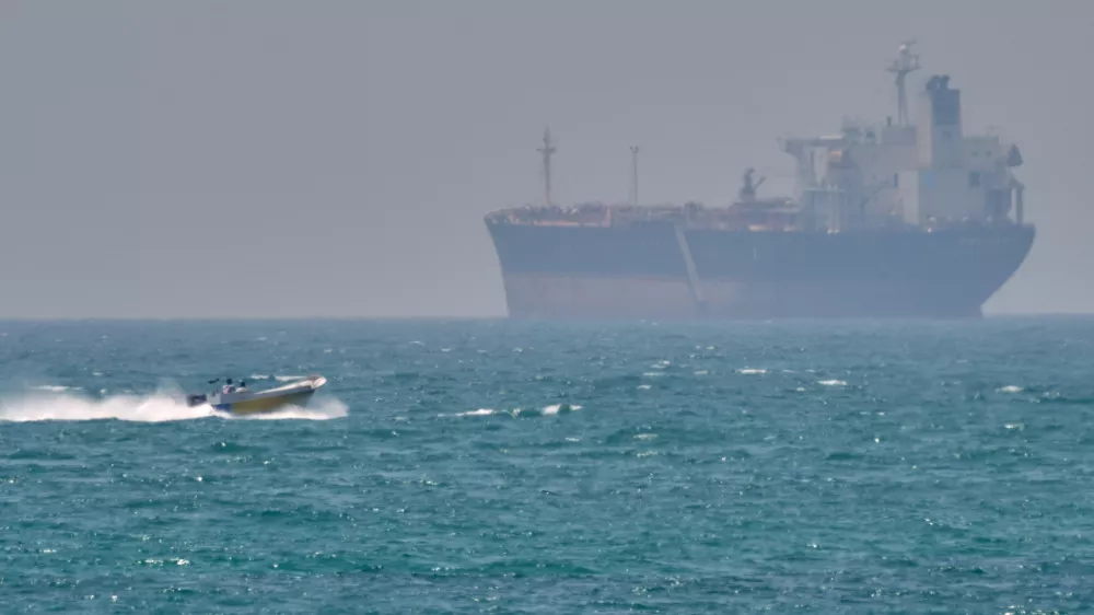 A boat sails past a tanker anchored on the Strait of Hormuz off the coast Qeshm island, Iran, Saturday, April 18, 2026. (AP Photo/Asghar Besharati)