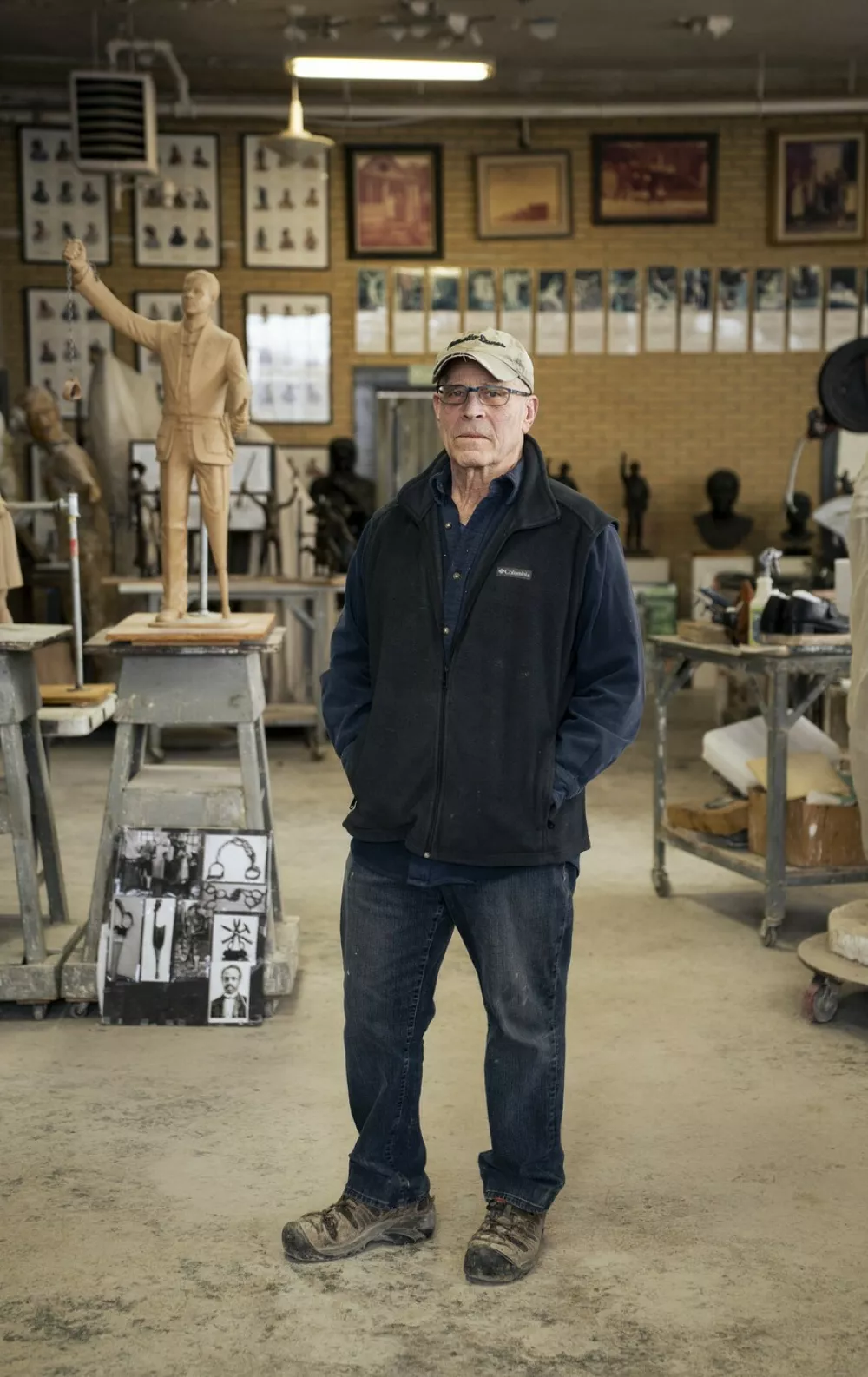 US sculptor Alan Cottrill, 73, poses for a portrait in his studio in Zanesville, Ohio, on February 5, 2026. Lying on its back at an Ohio sculpture studio, the 15-foot tall (4.6 meter) gold-leafed statue of US President Donald Trump dubbed "Don Colossus" by its creators is, perhaps, not quite at its best. The massive bronze work, slated to stand two-storeys tall once installed on a 6,000-pound (2,720-kg) base, depicts a defiant Trump raising his fist in the moments after he survived an assassination attempt in July 2024. But the $360,000 statue, commissioned by cryptocurrency entrepreneurs and backers of then-candidate Trump, has waited more than a year to be erected, partly because sculptor Alan Cottrill has yet to get paid.,Image: 1072712579, License: Rights-managed, Restrictions: To go with AFP story by Eli HILLER and Asad HASHIM: "'Don Colossus': Golden Trump statue crippled by crypto pay dispute", Model Release: no