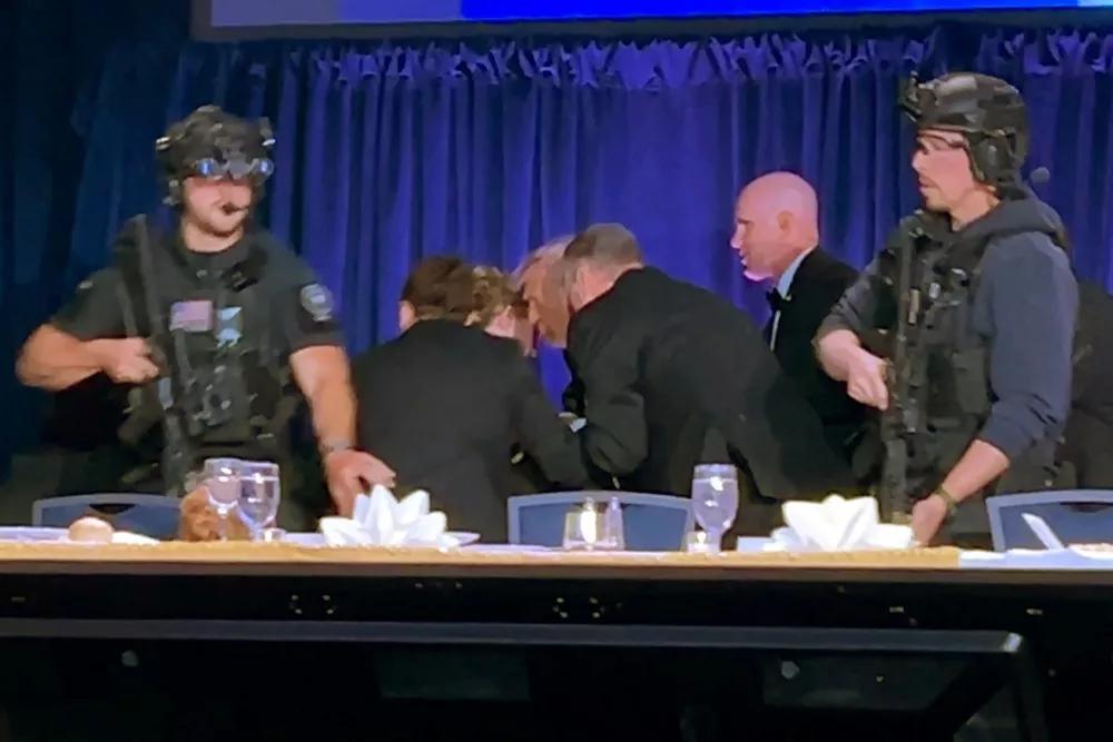 U.S. President Donald Trump is escorted out after a man opened fire with a shotgun on security personnel outside the room, during the annual White House Correspondents' Association dinner in Washington, D.C., U.S., April 25, 2026, in this still image from video. REUTERS/Bo Erickson THIS IMAGE WAS PROCESSED BY REUTERS TO ENHANCE QUALITY, AN UNPROCESSED VERSION HAS BEEN PROVIDED SEPARATELY.