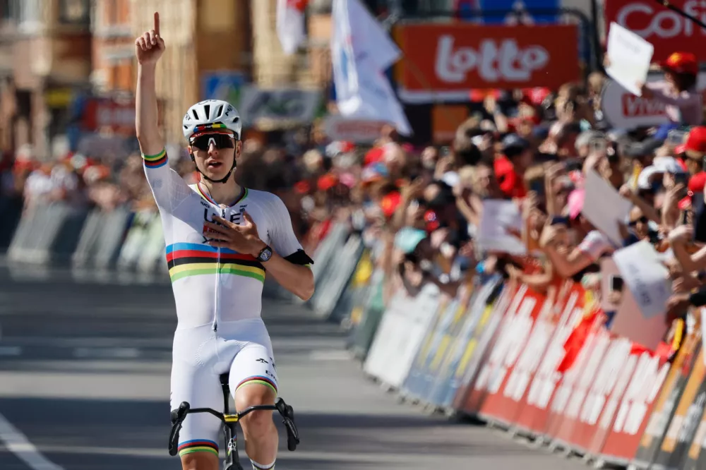 Slovenia's Tadej Pogacar of the UAE Team Emirates crosses the finish line to win the Belgian cycling classic and UCI World Tour race Liege Bastogne Liege, in Liege, Belgium, Sunday, April 26, 2026. (AP Photo/Geert Vanden Wijngaert)