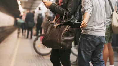 Thief stealing wallet from purse of a woman using mobile phone at the subway station. Pickpocketing at subway station