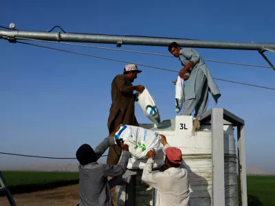 FILE PHOTO: Workers carry fertiliser bags to be mixed with water at a farm's irrigation center, where a newly launched 400 wheat hectares farm in Sharjah's Mleiha, which has turned a UAE desert into a green land, aims to further expand and reduce imports, in Mleiha area, Sharjah, United Arab Emirates, February 8, 2023. REUTERS/Rula Rouhana/File Photo
