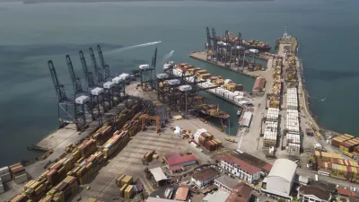 Cargo containers sit stacked as cranes load and unload containers from cargo ships at the Cristobal port, operated by the Panama Ports Company, in Colon, Tuesday, Panama, Feb. 4, 2025. (AP Photo/Matias Delacroix)