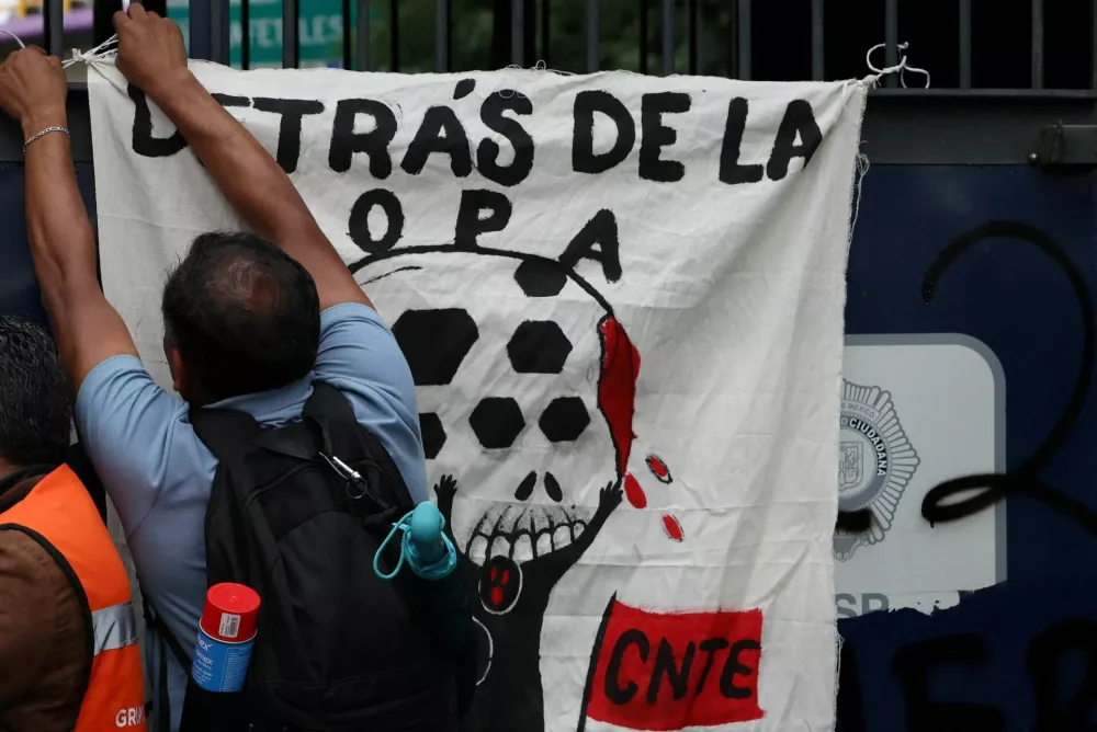 A demonstrator ties a banner on a fence while dissident teachers from Mexico's National Coordination of Education Workers (CNTE) take part in a protest heading towards Ciudad de Mexico Stadium, ahead of the 2026 FIFA World Cup in Mexico City, Mexico, June 9, 2026. REUTERS/Luis Cortes / Foto: Luis Cortes