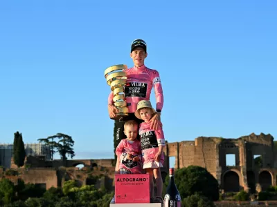 Cycling - Giro d'Italia - Stage 21 - Rome to Rome - Italy - May 31, 2026 Team Visma - Lease a Bike's Jonas Vingegaard celebrates on the podium with his daughter Frida, his son, and the trophy wearing the maglia rosa jersey after winning the Giro d'Italia REUTERS/Jennifer Lorenzini