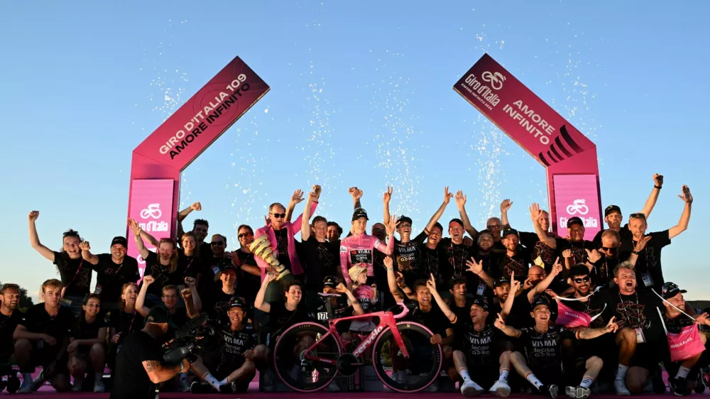 Cycling - Giro d'Italia - Stage 21 - Rome to Rome - Italy - May 31, 2026 Team Visma - Lease a Bike's Jonas Vingegaard celebrates on the podium with his daughter Frida, Team Visma - Lease a Bike CEO and general manager Richard Plugge, and teammates wearing the maglia rosa jersey after winning the Giro d'Italia REUTERS/Jennifer Lorenzini