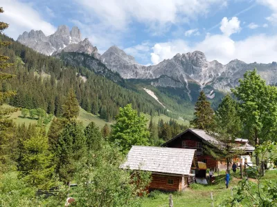 Nad dolino se dvigajo mogočni vrhovi Dachsteina, nad vasjo pa kraljuje značilni skalni stolp Bischofsm&uuml;tze, ena najbolj prepoznavnih gorskih silhuet v Avstriji.