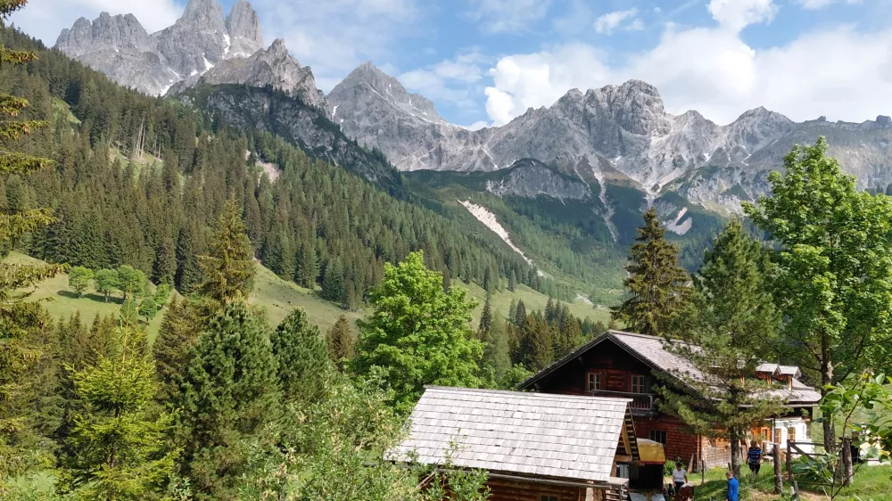 Nad dolino se dvigajo mogočni vrhovi Dachsteina, nad vasjo pa kraljuje značilni skalni stolp Bischofsm&uuml;tze, ena najbolj prepoznavnih gorskih silhuet v Avstriji.