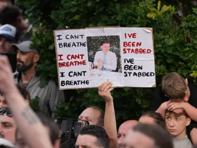 People protest outside the police station in Southampton, England, on Tuesday, June 2, 2026, one holding a photo of December 2025 stabbing victim Henry Nowak, 18. (Gareth Fuller/PA via AP)