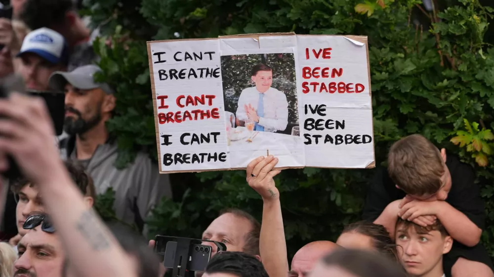 People protest outside the police station in Southampton, England, on Tuesday, June 2, 2026, one holding a photo of December 2025 stabbing victim Henry Nowak, 18. (Gareth Fuller/PA via AP)