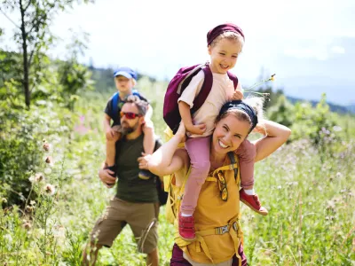 Front view of family with small children hiking outdoors in summer nature. / Foto: Halfpoint Getty Images