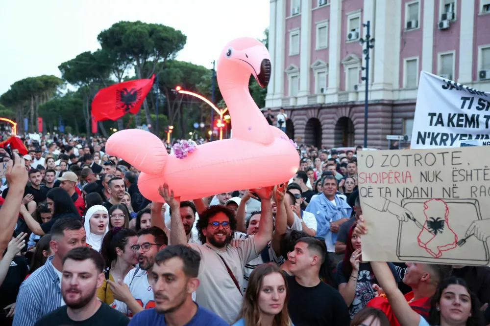Demonstrators hold banners and the Albanian flag as they protest against a luxury resort, a plan by a company linked to Donald Trump's son-in-law, Jared Kushner, in a protected area in Tirana, Albania, June 2, 2026. REUTERS/Florion Goga