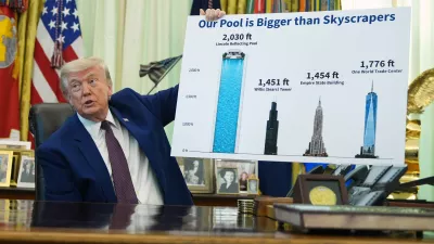 President Donald Trump holds a poster of the Lincoln Memorial Reflecting Pool, left, as he speaks in the Oval Office of the White House, Wednesday, June 3, 2026, in Washington. (AP Photo/Alex Brandon)