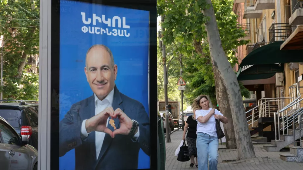 People walk past campaign banners with portraits of Prime Minister Nikol Pashinyan of the Civil Contract party, ahead of the June 7 parliamentary election, in Yerevan, Armenia June 3, 2026. Hayk Baghdasaryan/Photolure via REUTERS ATTENTION EDITORS - THIS IMAGE HAS BEEN SUPPLIED BY A THIRD PARTY.