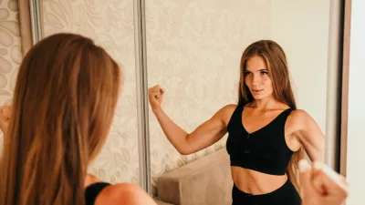Young woman with long hair, fitness instructor in black sportswear, doing stretching and pilates on yoga mat at home. Female fitness yoga routine concept. Healthy lifestyle harmony and meditation