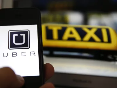 File illustration picture showing the logo of car-sharing service app Uber on a smartphone next to the picture of an official German taxi sign in Frankfurt, September 15, 2014. A Frankfurt court earlier this month instituted a temporary injunction against Uber from offering car-sharing services across Germany. San Francisco-based Uber, which allows users to summon taxi-like services on their smartphones, offers two main services, Uber, its classic low-cost, limousine pick-up service, and Uberpop, a newer ride-sharing service, which connects private drivers to passengers - an established practice in Germany that nonetheless operates in a legal grey area of rules governing commercial transportation.  REUTERS/Kai Pfaffenbach/Files (GERMANY - Tags: BUSINESS EMPLOYMENT CRIME LAW TRANSPORT)