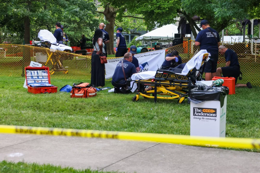 First responders help a woman who was injured the mass shooting that left 12 people injured at the Old West End Festival at the Agnes Reynolds Jackson Arboretum in Toledo, Ohio, on Saturday, June 6, 2026. (Rebecca Benson/The Blade via AP)