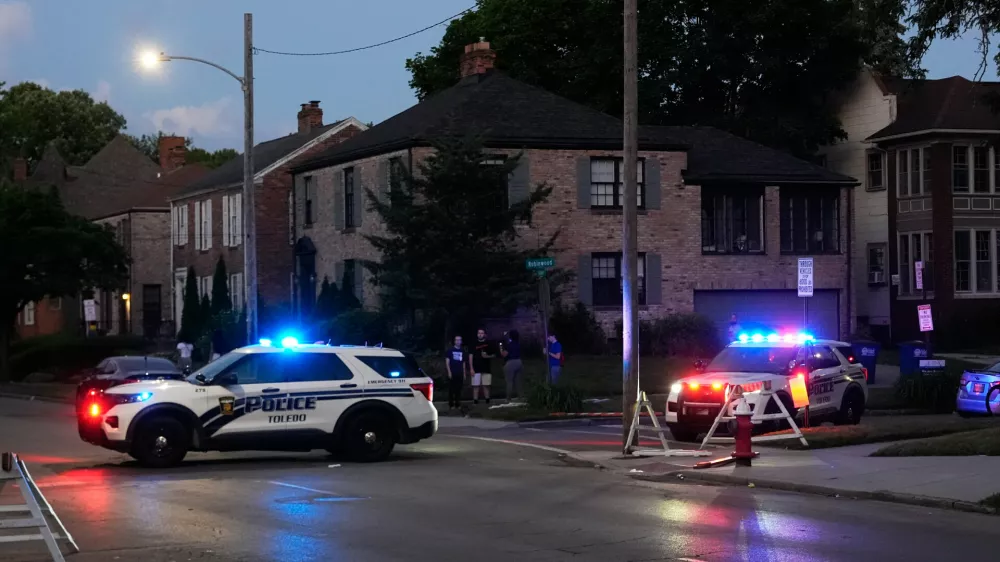 Police stand near where multiple people were shot at a community festival at the Agnes Reynolds Jackson Arboretum Saturday, June 6, 2026, in Toledo, Ohio. (AP Photo/Paul Sancya)
