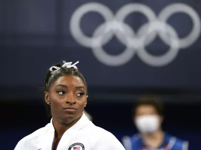 FILE - In this July 27, 2021 file photo, Simone Biles, of the United States, watches gymnasts perform after she exited the team final at the 2020 Summer Olympics, in Tokyo. Biles, who redefined excellence in gymnastics and picked up seven Olympic medals along the way, drew attention and, from some, criticism by pulling out of events in Tokyo because of a mental block that made her afraid to attempt certain dangerous moves. (AP Photo/Ashley Landis, File)