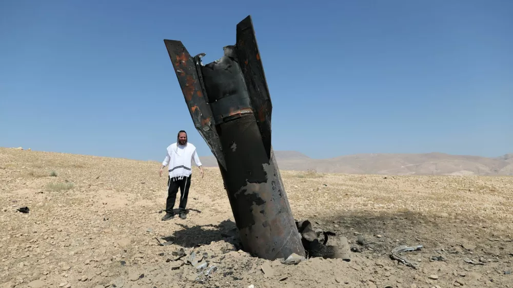 An Israeli ultra-Orthodox Jewish man reacts near a part of a missile protruding from the ground, following strikes from Iran, in the central Israeli-occupied West Bank, June 8, 2026. REUTERS/Ammar Awad